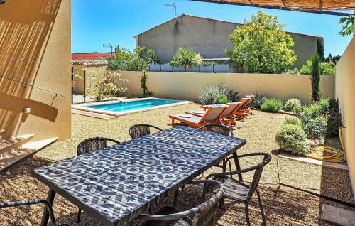 un patio avec une table et des chaises et une piscine dans l'établissement Villa Lilou, à Maillane