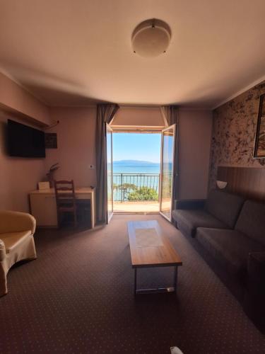 a living room with a couch and a view of the ocean at VILLA VOLOSKO with private parking and breakfast,seaview in Volosko