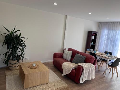 a living room with a red couch and a table at Casa Blu in Port Noarlunga South