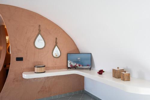 une télévision posée sur une étagère dans une pièce dans l'établissement Villa Chora, à Fira