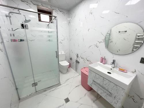 a bathroom with a shower and a sink and a mirror at Villa with a pool & close to the sea in Baku