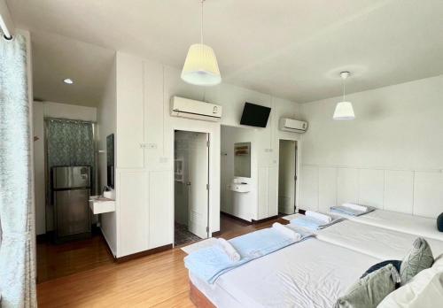 a large room with three beds and a bathroom at Thirty Tree Garden House in Chumphon