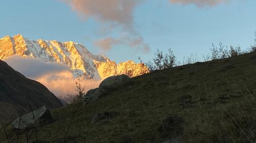 a view of a mountain with the sun shining on it at Nizharadze's Tower in Ushguli