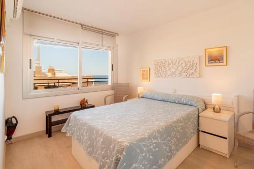 a bedroom with a bed and a large window at Inspira by Unik Vacation in Torredembarra
