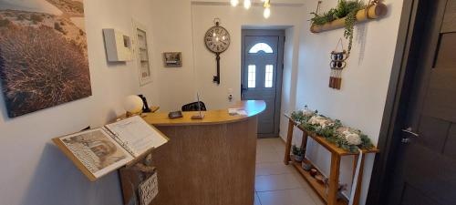 a hallway with a desk and a clock on the wall at Selinopetra Rooms in Elafonisos