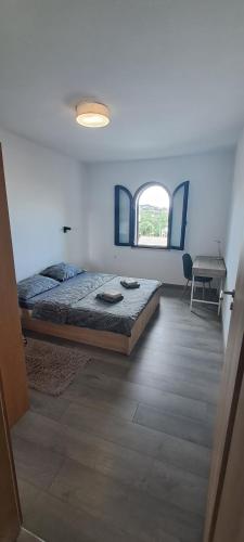 a bedroom with a bed and a desk and a window at Family Apartment Maria in Matulji