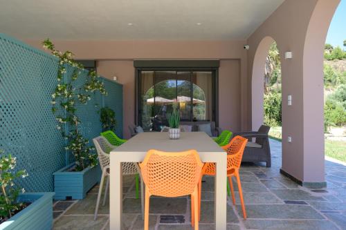an outdoor patio with a white table and chairs at Antinea Olympian Villa in Olympia