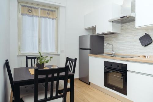 een keuken met een tafel, stoelen en een koelkast bij Domus Clelia in Rome