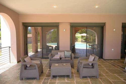 a living room with a couch and chairs on a porch at Antinea Olympian Villa in Olympia