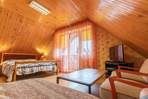 a bedroom with two beds and a tv in a room at Po Kastonu & SPA in Palanga