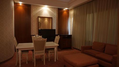 a living room with a table and chairs and a couch at Golden Beach by ShamBaku in Baku