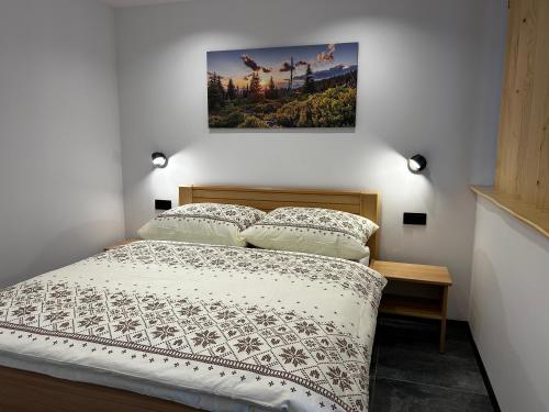 a bedroom with a bed with a picture on the wall at Horska Rezort in Ružomberok