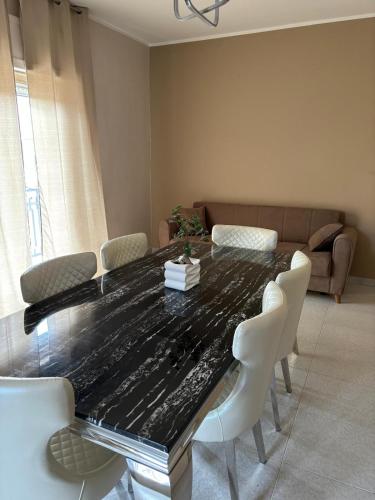 a dining room table with chairs and a couch at Residence San Ferdinando in San Ferdinando di Puglia