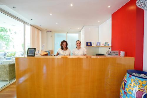 two women standing at a counter in an office at Hotel Luxor in Rimini