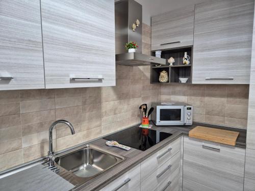 eine Küche mit einer Spüle und einer Mikrowelle in der Unterkunft A casa di Antonella in Portopalo