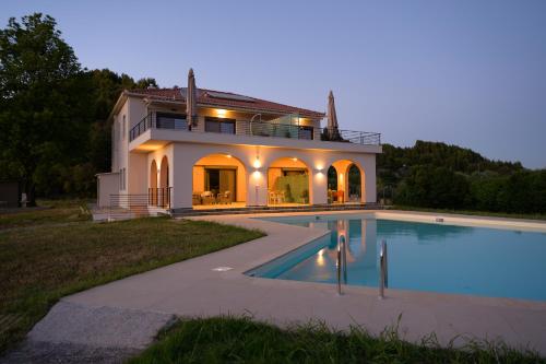 a house with a swimming pool in front of it at Antinea Olympian Villa in Olympia