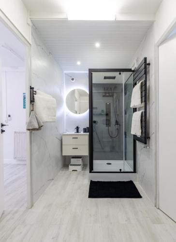 a white bathroom with a shower and a sink at Bista Eder in Pyla-sur-Mer