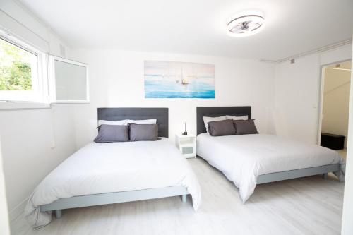 two beds in a room with white walls at Bista Eder in Pyla-sur-Mer