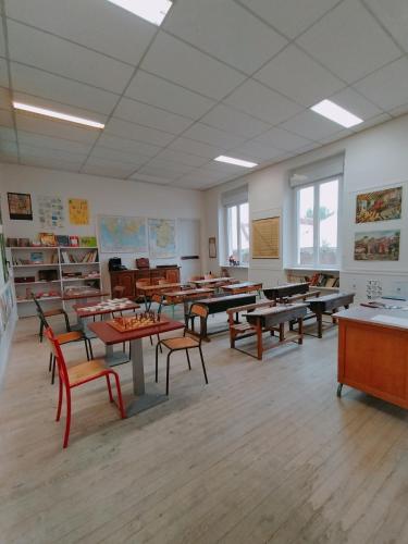 a classroom with tables and chairs in a classroom at L'école buissonnière in Laroque-dʼOlmes