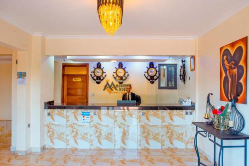 a man sitting at a bar in a hotel lobby at Mountain View Hotel & Apartment in Kigali