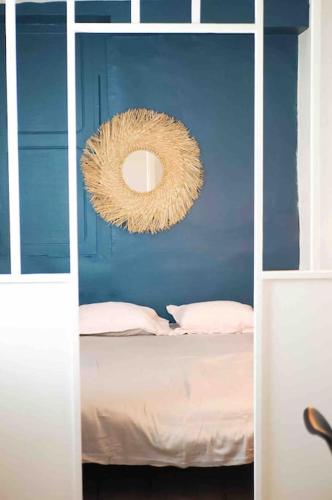 Cette chambre bleue comprend un lit et un miroir. dans l'établissement Superbe appartement vieux port de La Rochelle EMPLACEMENT IDEAL WIFI, à La Rochelle