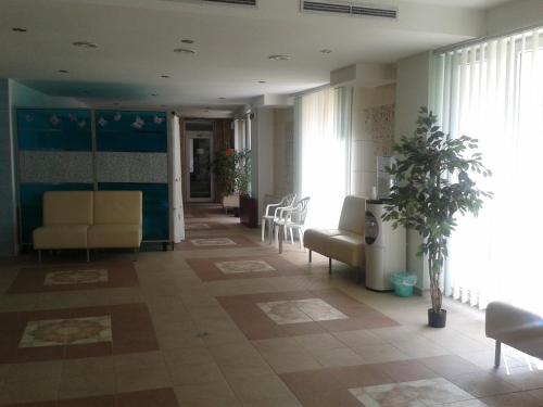 a lobby with a waiting room with chairs and plants at Hotel Vila Anna in Trenčianske Teplice