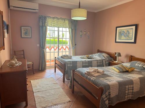 1 dormitorio con 2 camas y ventana en Villa Mar, en Albufeira
