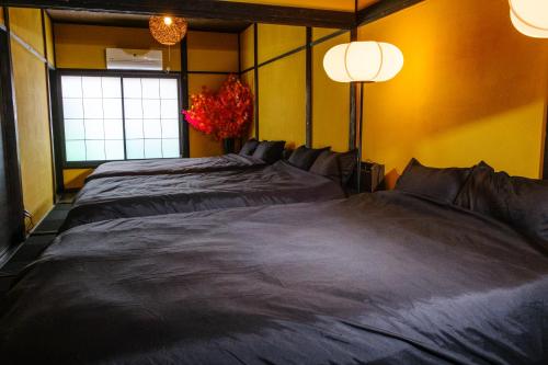 a bedroom with two beds and a window at TRAVELERZ YOKOHAMA Demon Slayer House in Kikuna