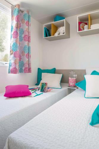 une chambre avec deux lits et une fenêtre dans l'établissement camping Le moulin, à Patornay