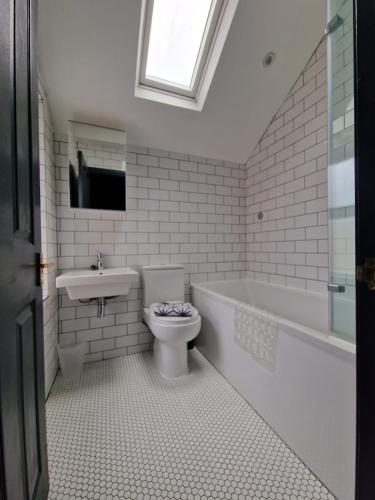 a bathroom with a toilet and a sink and a tub at Lovely 3 bedroom Whitley Bay Townhouse. in Whitley Bay