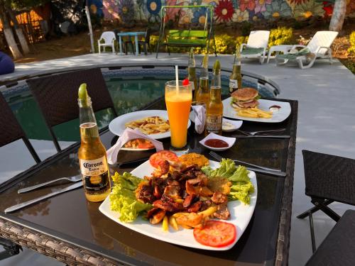 un tavolo con piatti di cibo e bottiglie di birra di Green Door San Gil a San Gil