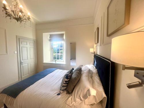 a bedroom with a bed and a lamp and a window at 9 Bedroom all Ensuite- Exclusive Use in Auchterarder