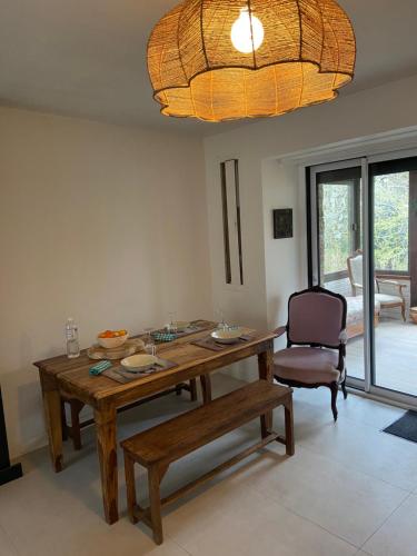 a dining room with a wooden table and a chair at Ker Lann in Paimpont
