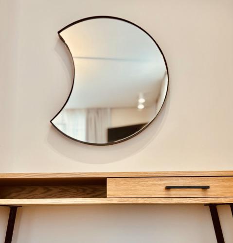 a mirror on a wall above a dresser at Iridium Old Town Luxury Suites in Kavala