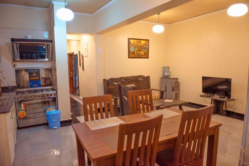 a dining room with a table and chairs and a television at Mountain View Hotel & Apartment in Kigali