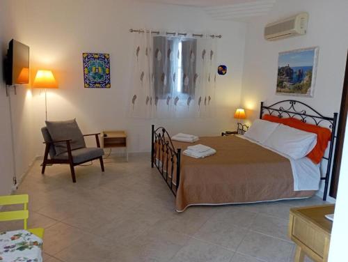 a bedroom with a bed and a chair in a room at millennium holiday in Castellammare del Golfo