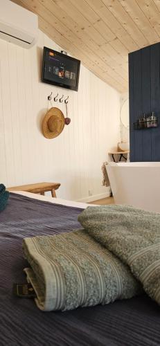 a bed in a room with a clock on the wall at Les Cocons d AleXan Le Chalet balnéo aromathérapie in Quinssaines
