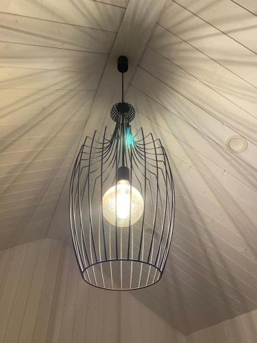 aendant light hanging from a ceiling in a room at Hamar - Puffin Cottages & Rooms in Hvolsvöllur