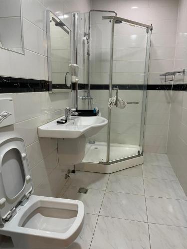 a bathroom with a toilet and a sink and a shower at Hotel 5092 in Abuja