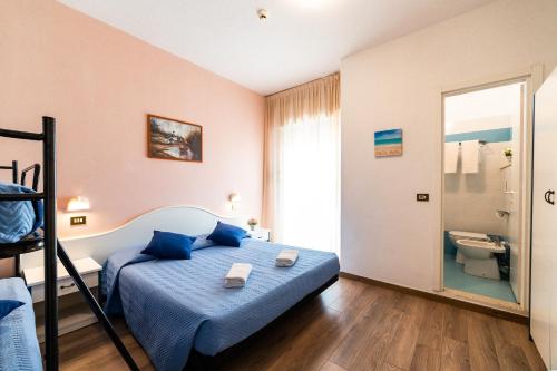 una camera con letto blu e un bagno di Hotel Tivoli a Misano Adriatico
