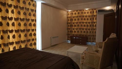 a bedroom with a bed and a table and a window at Golden Beach by ShamBaku in Baku