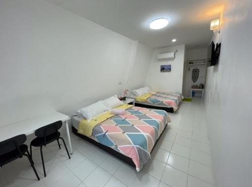 two beds in a room with a table and chairs at WIWI Village in Kemasik