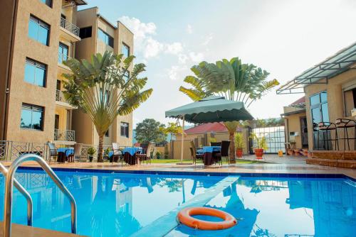 a swimming pool at a hotel with palm trees at Mountain View Hotel & Apartment in Kigali