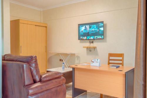 a living room with a leather chair and a desk at Mountain View Hotel & Apartment in Kigali