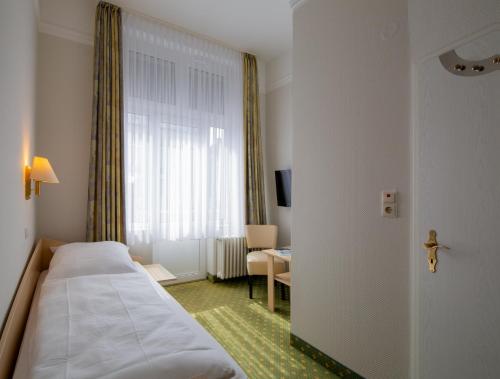 a hotel room with a bed and a window at Logierhaus Extra in Norderney