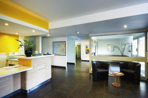 a living room with a counter and chairs in a room at ibis budget Chartres in Chartres