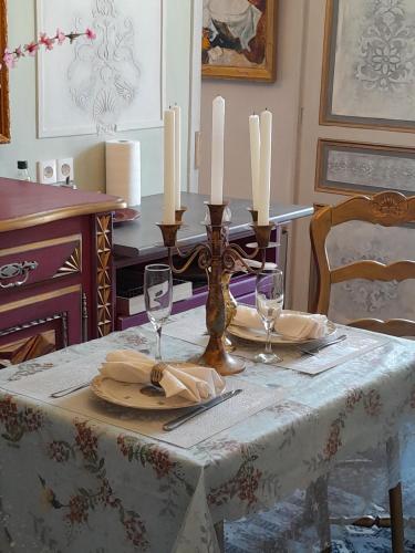 une table avec deux bougies et une table avec des chaises dans l'établissement Appartement de Ville Médiévale, à Vinça