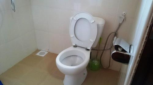 a bathroom with a toilet with the lid up at Ubuntu Palace Hotel in Kampala