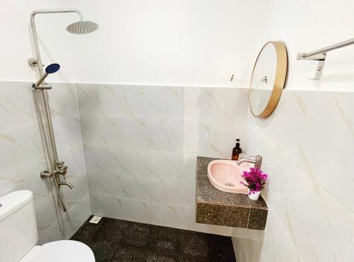 a bathroom with a sink and a toilet and a mirror at WIWI Village in Kemasik