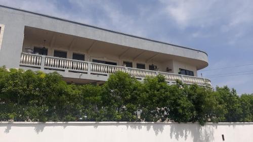 a white building with a balcony on top of a wall at ShkyBlue Suites in Christ Church